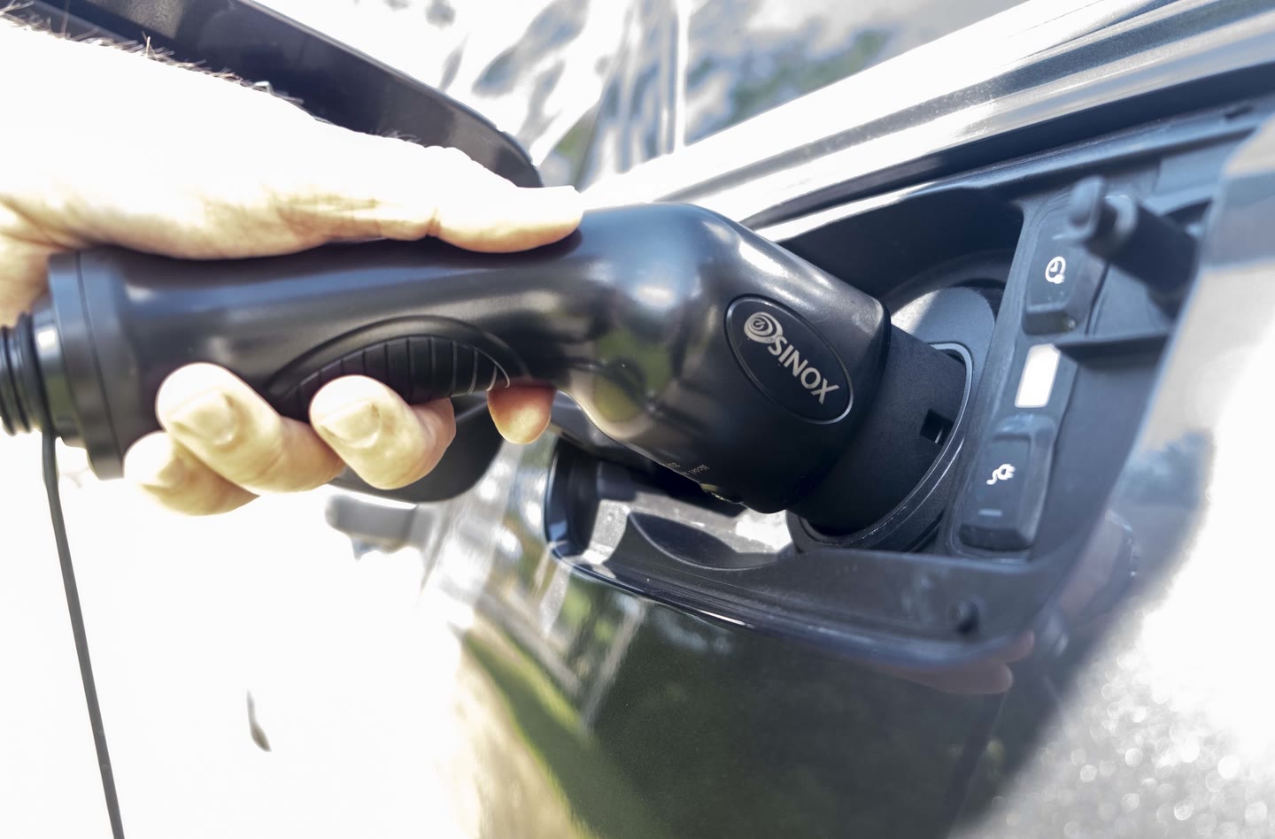 SINOX EV charging plug connected to electric car